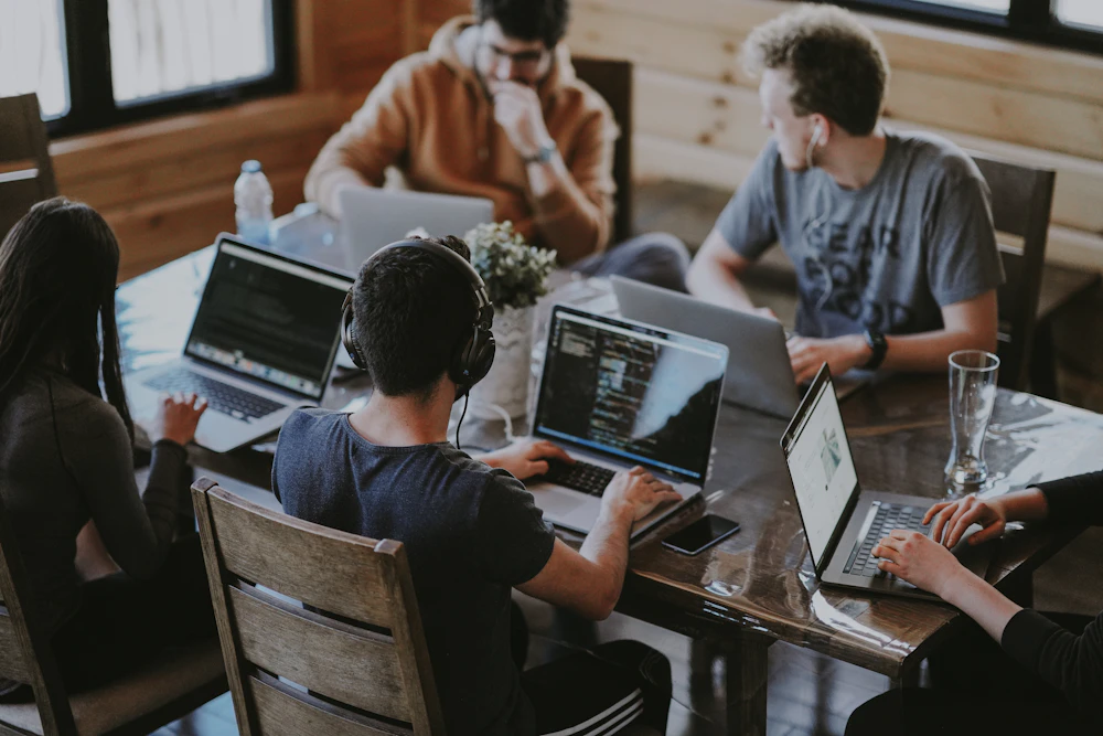 IT consultants collaborating on a network strategy across several laptops